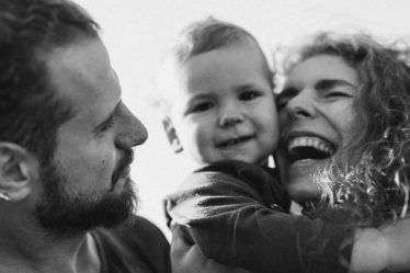 A happy family enjoying a heartfelt moment together in a black-and-white setting.